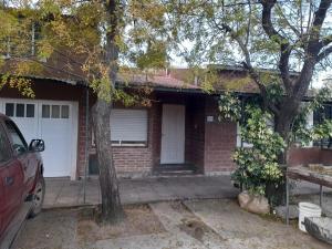a brick house with a car parked in front of it at Ruca in Bragado