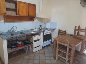 a kitchen with a sink and a stove and a table at Ruca in Bragado