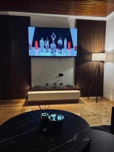 a living room with a large tv on the wall at Vikendica Dajana in Banja Luka