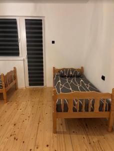 a bedroom with a bed and a wooden floor at Vikendica Dajana in Banja Luka +2 photos