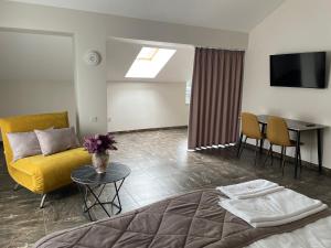 a living room with a yellow couch and a table at Hiking&Ski Hotel in Bukovel