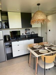 a kitchen with a table and some chairs and a kitchen with at Retour de Plage in Saint-Pair-sur-Mer