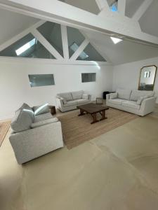 a living room with two couches and a table at Retour de Plage in Saint-Pair-sur-Mer