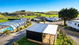 an aerial view of a house with a greenhouse and a yard at Retour de Plage in Saint-Pair-sur-Mer