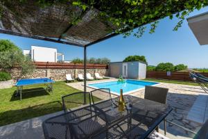 a patio with a table and a swimming pool at Holiday house Casa Vida in Rakalj