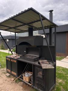 an outdoor grill with a roof on top of it at Пан0рама in Saty
