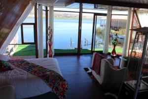 a living room with a view of the water at Titicaca Wara wara Lodge in Puno
