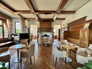 a living room with tables and chairs and a fireplace at Hôtel & Résidence Vacances Bleues Orhoïtza in Hendaye