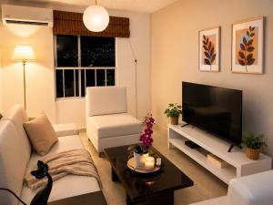 a living room with a white couch and a television at Espectacular! Apartamento en cali cerca al coliseo del pueblo in Cali