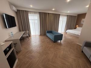 a hotel room with a bed and a blue chair at Delmont hotel in Kostanay