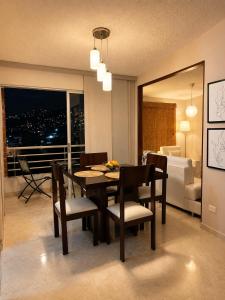 a dining room with a table and chairs and a bedroom at Espectacular! Apartamento en cali cerca al coliseo del pueblo in Cali