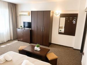 a hotel room with a bed and a table and a tv at Casa Mario in Eforie Nord +30 photos
