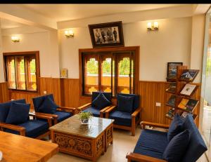 a living room with blue chairs and a table at Tshang Tshang Villa in Paro