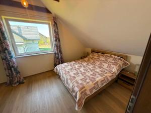 a bedroom with a bed and a large window at Leśna przystań in Trupel