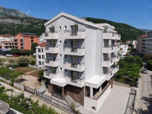 an apartment building with balconies on a city street at Hotel Fineso in Budva