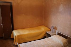 a small room with two beds and a night stand with a bedskirts at la casa nell'acropoli , piano terra in Arpino