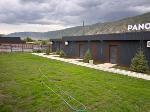a building with a hose in the grass in a yard at Пан0рама in Saty +24 photos