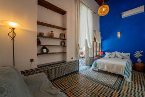 a bedroom with blue walls and a bed in a room at Riad Lik in Fez +34 photos