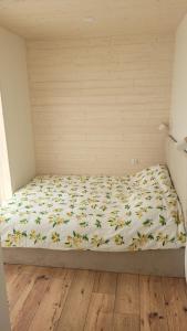 a bed in a room with a bedsheet with flowers on it at Wiosłem w Hamaku Domek nad Wkrą in Rybitwy