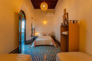 a bedroom with a bed and a mirror at Riad Lik in Fez