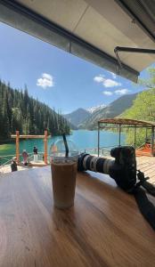 a drink sitting on a table next to a camera at KolsayNestAframe in Saty