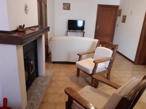a living room with two chairs and a fireplace at la casa nell'acropoli , piano terra in Arpino