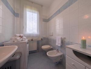 a bathroom with a toilet and a sink and a candle at -1 min dal mare- AC balcone e garage in Pedaso +24 photos