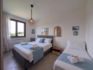 two beds in a hotel room with towels on them at -1 min dal mare- AC balcone e garage in Pedaso