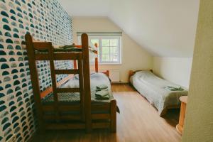 a room with a bunk bed and a couch at Beachside Guest House Piejuras nams in Ķesterciems