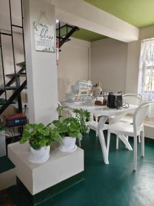 a room with a table and chairs with plants at Cozy corner Homestay in Mawphlang