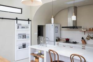 a kitchen with a white counter and a refrigerator at 不觉晓晨曦花园别墅 Bujuexiao Dawn Garden Villa Shanghai - Free daily shuttle bus to Disneyland, exquisite and beautiful garden courtyard, private spa bathtub in each room, hearty daily breakfast provided for all guests in Shanghai