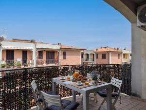 a table with fruit on a balcony with buildings at -1 min dal mare- AC balcone e garage in Pedaso