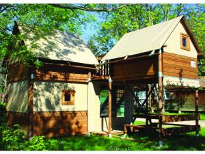 una pequeña casa de madera con techo de gambrel en Camping des Papillons, en Lalizolle