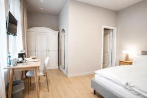 a bedroom with a bed and a desk and a table at Hotel Schloss Teutschenthal in Teutschenthal