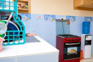 a kitchen with a red stove top oven sitting on a counter at Almarg homes in Nakuru