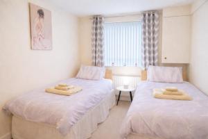 a bedroom with two beds with towels on them at Portstewart promenade apartment with sea views in Portstewart