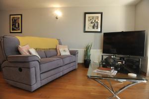 a living room with a couch and a flat screen tv at Portstewart promenade apartment with sea views in Portstewart