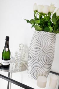 a bottle of wine and a vase with flowers on a table at Cameo B&B in Rome