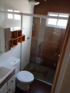a bathroom with a toilet and a glass shower at Pousada Marlin in Dois Vizinhos