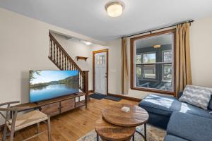 a living room with a blue couch and a tv at The Longfellow Bungalow in Minneapolis