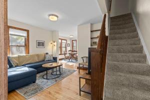 a living room with a blue couch and stairs at The Longfellow Bungalow in Minneapolis