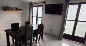 a dining room with a table and a television on the wall at Loft zona centro La Merced in San Cristóbal de Las Casas