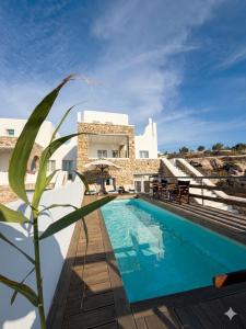 a villa with a swimming pool in front of a building at Parfait Villa, Mykonos in Agios Ioannis Mykonos