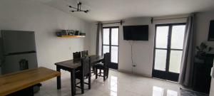 a dining room with a table and chairs and a television at Loft zona centro La Merced in San Cristóbal de Las Casas