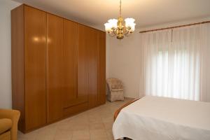 a bedroom with a bed and a cabinet and a chandelier at Natura e Relax Casa Emma in Buonvicino