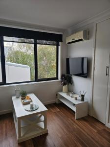 a living room with a table and a large window at Richmond apartment close to MCG in Melbourne