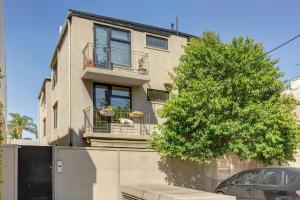 a building with a tree in front of it at Richmond apartment close to MCG in Melbourne
