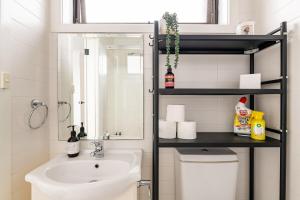 a bathroom with a sink and a toilet and a mirror at Richmond apartment close to MCG in Melbourne +16 photos
