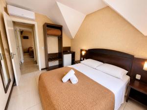 a bedroom with a bed with a white towel on it at Pousada Nosso Lar in Gramado