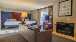a hotel room with a bed and a fireplace at Sonesta ES Suites Albuquerque in Albuquerque
